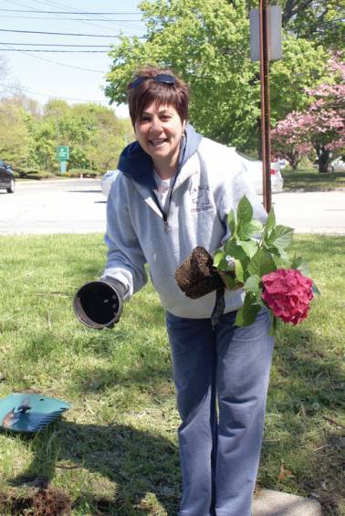 FLOWER POWER: Donna Andreozzi, a friend of the Pastore family, gets ready to plant a flower in the Dialogue Garden in memory of the late Peter Pastore Jr.