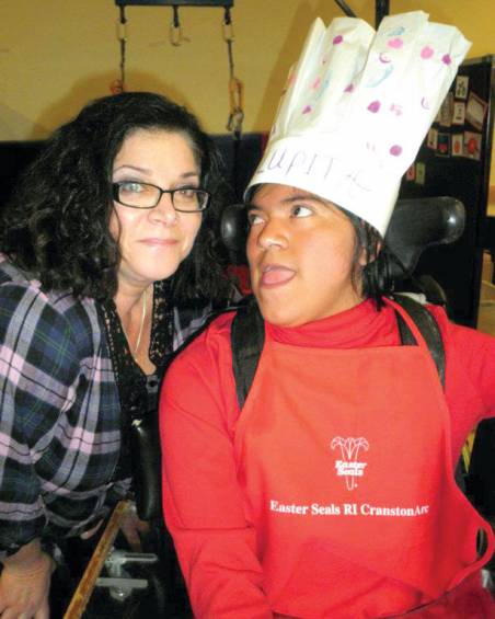 BUILDING UP AN APPETITE: Instructional assistant Donna Carroll poses with student Lupita Flores, who wears a chef&rsquo;s hat in honor of the visit.