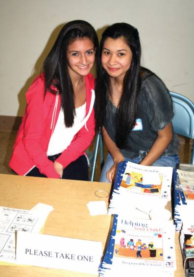COMMUNITY SERVICE TIME: There were many students from Cranston High Schools East and West volunteering their time for their community service hours. Stephanie Kaiser and Elva Gomez, both seniors at Cranston East, worked at a game table, showing the students how to play learning games like Memory.