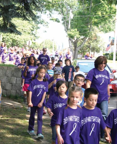 HERE THEY COME: A sea of purple could be seen walking through the Eden Park neighborhood as the students chanted their support for Kelsey and her fight against cancer.