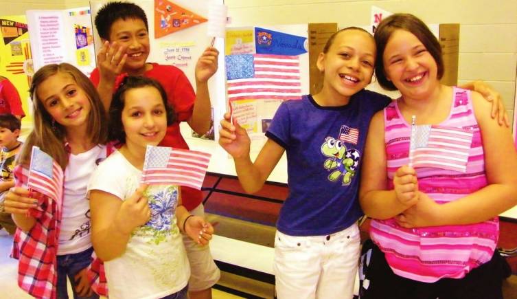 Here, from left, Kaitlyn Greco, Patrick Bui, Leah Connolly, Jessy Hughes and Sarah Healy wave their American flags in front of several of their projects.