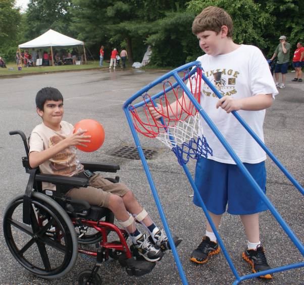 SOON TO SWISH: Ready to make a basket is Ryen Lara of Cornerstone School assisted by Eddie Regan, age 11, who volunteered during the Olympic Family Fun Day.