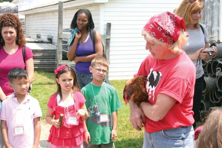SO THAT'S HOW YOU HOLD A CHICKEN: Sean Yang, Gabrielle Valletta and Matthew Menna look on as Cindy Morris talks about raising chickens and gathering eggs at Morris Farm.
