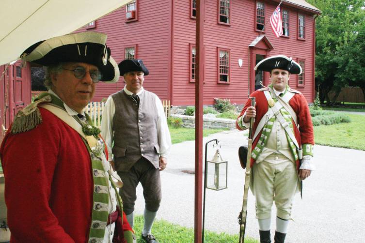 WELCOMING PARTY: Dennis Pacheco, left, Joseph Henry and Erik Pacheco stand ready to greet visitors to a tour of the Captain Peter Greene house in Conimicut.