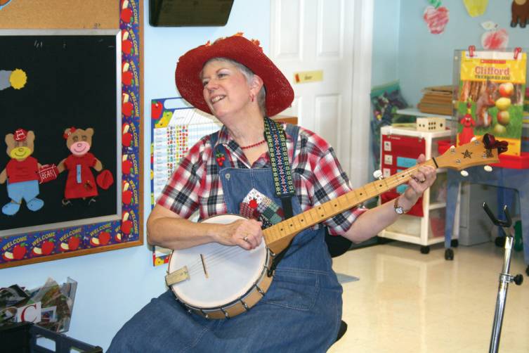Apple Annie, played by Anne-Marie Forer, plays her banjo for the class.