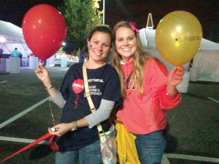 UP UP AND AWAY: Brittany Wardell and Whitney Goulish hold up their balloons and keep smiling, despite the damp weather at Light the Night.