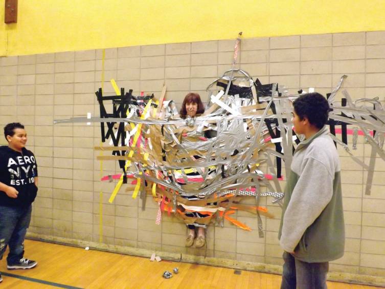 IT ACTUALLY WORKED: Seventh grade math teacher Joanne Spaziano is stuck to a wall with duct tape by her students. It was a reward for bringing in cans for the school's holiday food drive.