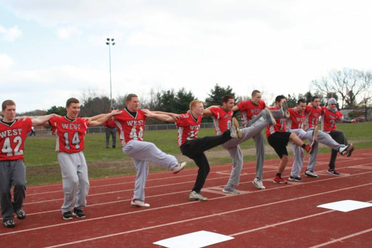 ANYONE CAN DO IT: Members of the Cranston High School West football team show up the Falconettes and Westernettes as they performed a kick line of their own.