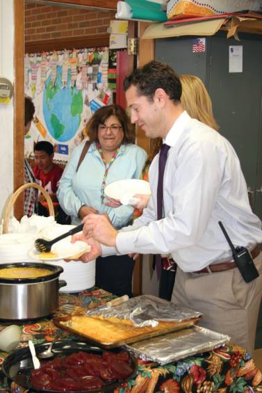 BACK FOR SECONDS: Principal Joe Rotz fills his plate at the ELL hosted Thanksgiving Dinner.