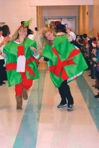 Sara Radtke and Kimberly Hatton volunteer their time as &ldquo;presents&rdquo; and lead the way for Mr. and Mrs. Claus.