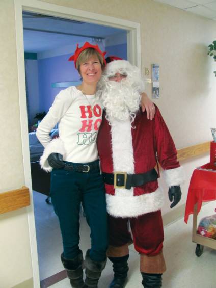 Penny Riddensdale, the activities director at Briarcliffe Manor, gives Santa Claus a hug during his rounds to distribute gifts to each resident at Briarcliffe.