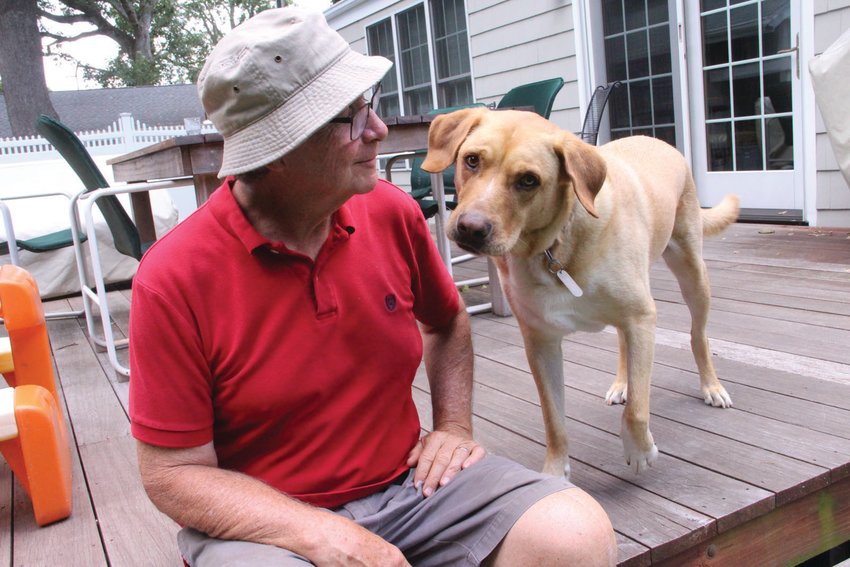 UNMASKED AND BEST OF FRIENDS: Tom Sanford and his rescue lab Cam in the backyard of their Warwick home.