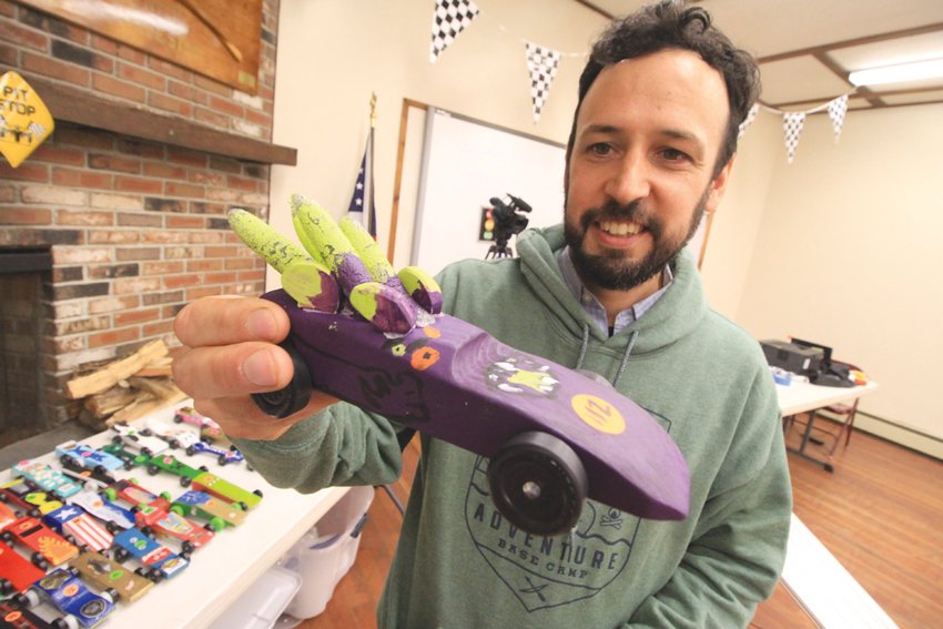 IT JUST LOOKS FAST: Joram Northup displays one of the 150 Pinewood Derby racers entered into the Narragansett Council championships held Friday. Liam Maxwell of Pack 13 Centerville in North Providence, built the car.