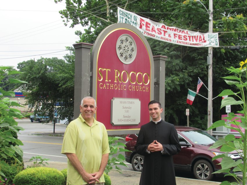 DIVINE DUTY: Richard Montella (left), long-serving co-chairman of the now 81-year-old Saint Rocco&rsquo;s Fest and Festival, is joined by Seminarian Stephan Coutcher outside the Roman Catholic Church conveniently located on the corner of Plainfield Pike and Atwood Avenue in Johnston.