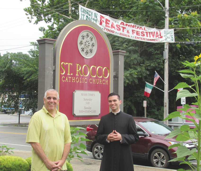 DIVINE DUTY: Richard Montella, left, long-serving co-chairman of the now 81-year-old Saint Rocco&rsquo;s Feast and Festival, is joined by Seminarian Stephan Coutcher outside the Roman Catholic Church conveniently located on the corner of Plainfield Pike and Atwood Avenue in Johnston. (Sun Rise photos by Pete Fontaine) PIX TWO IMG 4178