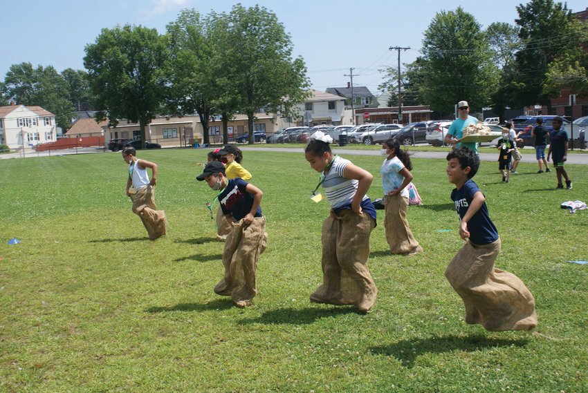 A HOP AWAY: Students celebrated the completion of Camp XL at Bain Middle School, enjoying activities such as sack races.&nbsp;