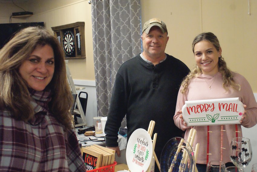 FAMILY MATTER: Maria Manzi, president of the St. Mary&rsquo;s Feast Society Ladies&rsquo; Auxiliary, is seen with her daughter, Brittny Richards, and her father, George Huddleston, manning the craft booths &ldquo;I GY 6 Woodcrafts&rdquo; and &ldquo;Family Creations.&rdquo;