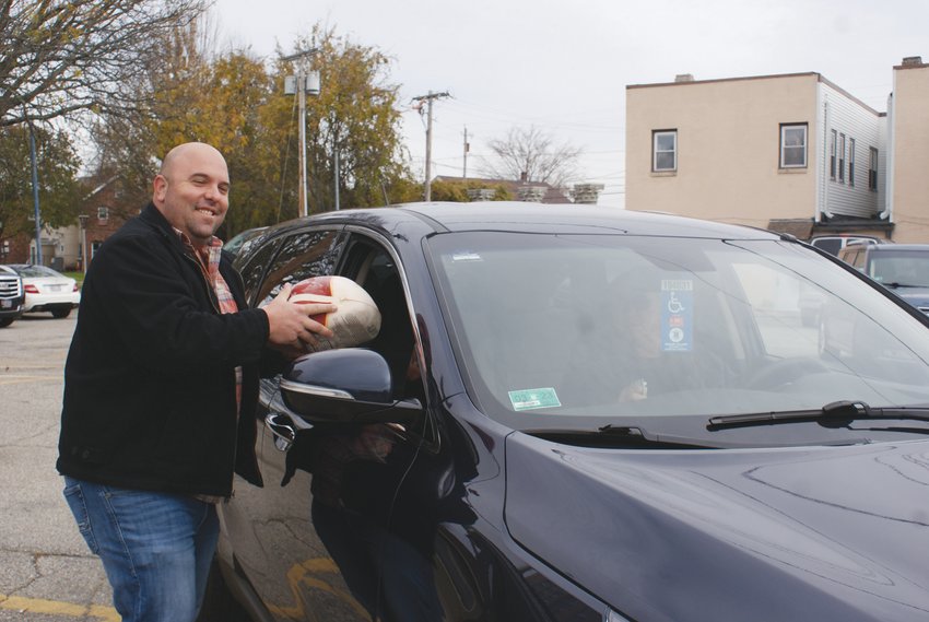 WITH SERVICE: Matthew Volpi, President of the St. Mary&rsquo;s Feast Society, hand delivers a free frozen turkey to a family in need this holiday season.