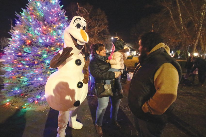 PLENTY OF FRIENDS: Olaf from the Disney film Frozen was a hit at the tree lighting ceremony in front of Thayer Arena. FACE CANES: Rachel Channen of the Warwick Boys and Girls Clubs put her artistic talents to use Sunday painting candy canes of the faces of visitors to the city&rsquo;s Christmas celebration at Thayer Arena. Here Lindon Feriolli gets his cane.