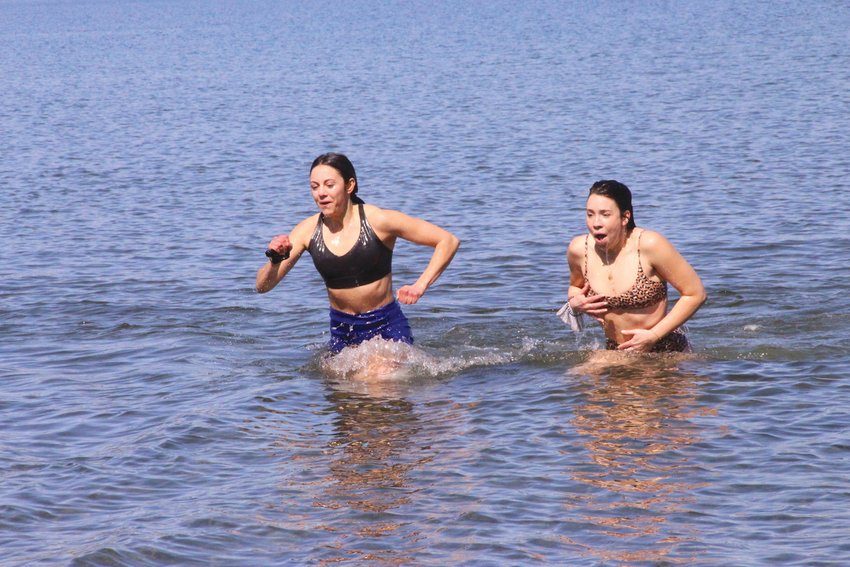 MAKE IT QUICK: Ali McGowan and Sarah Crowell make  a dash for the beach after the Mentor RI dip help in  March. Warwick Beacon file photo)