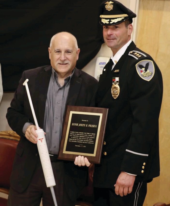 BIG SHOT: Johnston Mayor Joseph M. Polisena in all smiles after receiving two awards &mdash; an inflated syringe and the JPD&rsquo;s Civilians Award for Meritorious Acts &mdash; from Police Chief Joseph Razza during the recent Recognition of Excellence Ceremony.