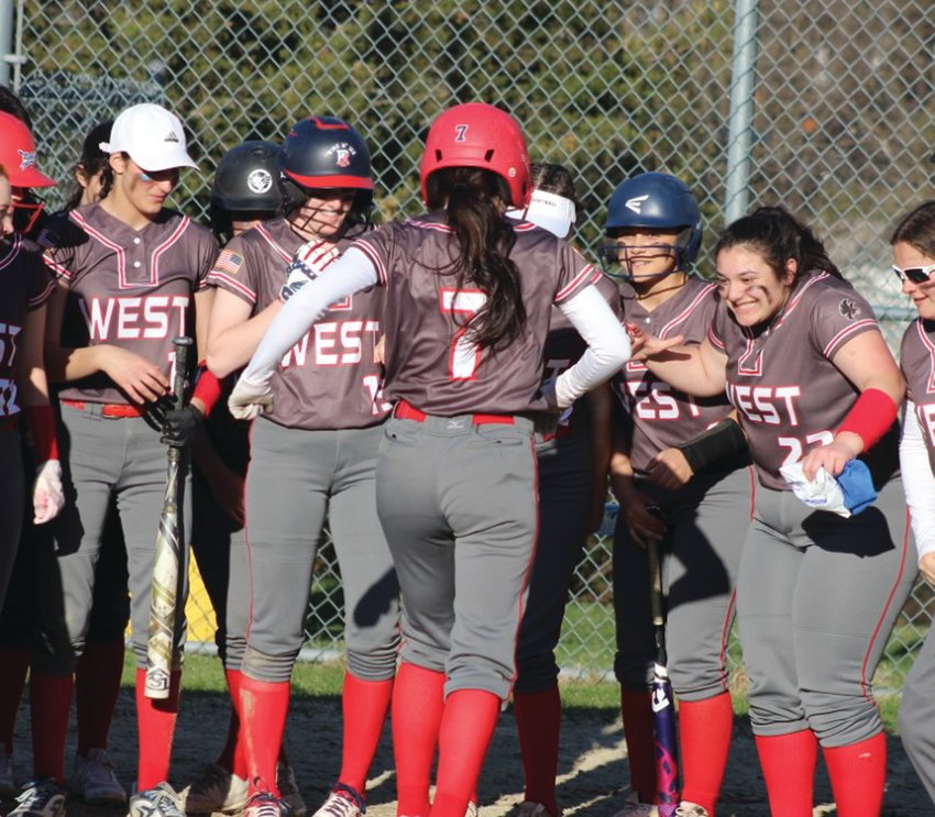 HOME RUN: The West softball team waits at home plate to celebrate a home run. (Photos by Alex Sponseller)