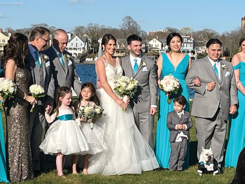 Caitlin and Bryan Schnell gather with their parents, wedding attendants, and their French bulldog, Calvin, at Gurney&rsquo;s Newport Resort on Goat Island.