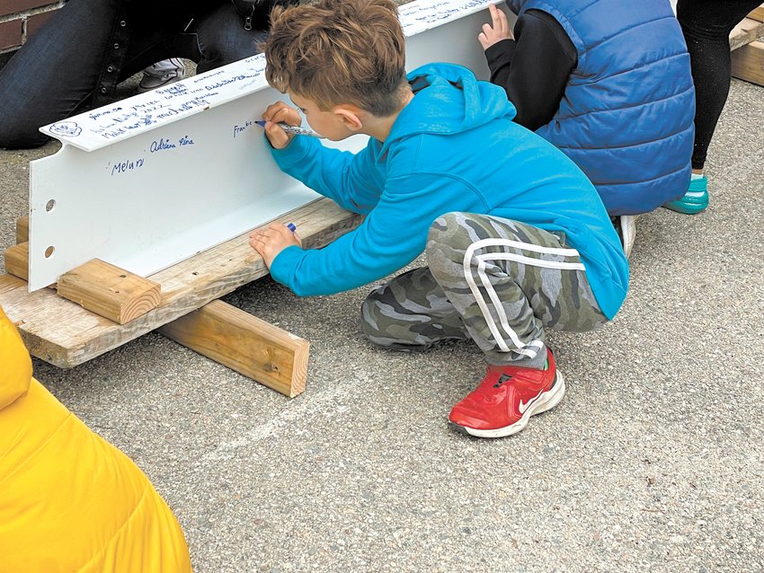 FOREVER A PART OF THE SCHOOL: Second grader Frank Peters adds his name to the steel beam at a ceremony for the Garden City Elementary School community on April 26. Read more on page 7. (Photo courtesy of Cranston Public Schools)