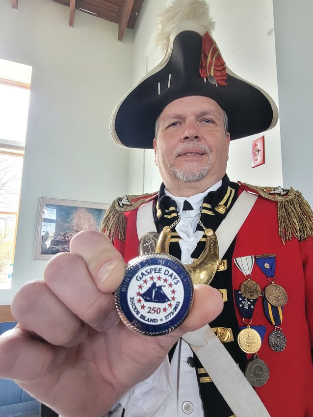 CHALLENGE COIN: Col. Ron Barnes, Commander of the Pawtuxet Rangers, holds a challenge coin. Barnes presented a similar coin to Britain&rsquo;s Consul General for New England Dr. Peter Abbott OBE, during an announcement event for an underwater search for the Gaspee&rsquo;s remains. If Barnes challenges Abbott to show the coin while out for drinks, and Abbott can&rsquo;t produce it, the tab&rsquo;s on the Brits. If he challenges and Abbott produces the coin, drinks are on the Pawtuxet Rangers.
