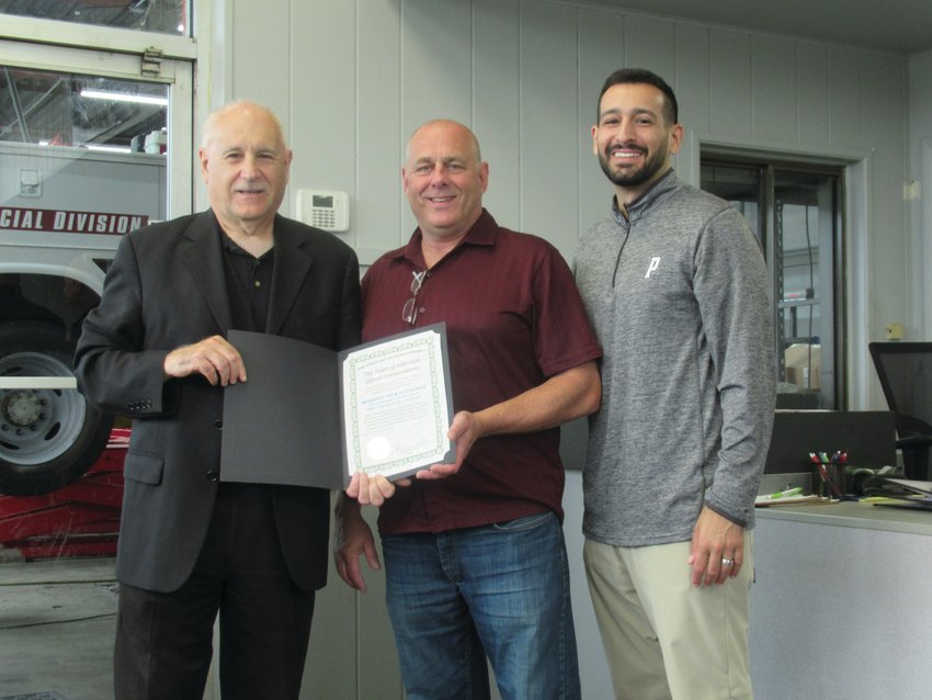 WARM WELCOME: Johnston Mayor Joseph Polisena presents an Official Town of Johnston Commendation to Jim Hallenbeck, owner-operator of Broadway Tire located at 1307 Hartford Ave. and is joined by his son Town Council Vice President Joseph Polisena Jr. during the recent ribbon cutting ceremony.