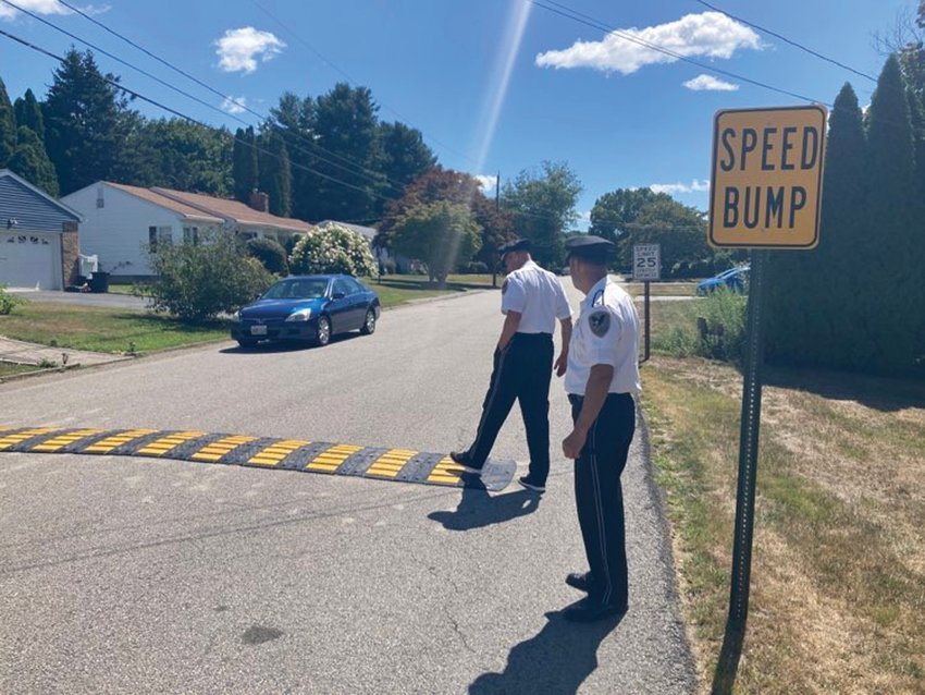 NEW SPEED HUMP: Johnston Police Chief Joseph Razza and Deputy Chief Mark Vieira inspect a new speed hump as a car crosses it on Cavalcade Boulevard.