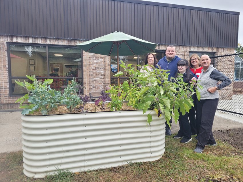 SEEDING SUCCESS: From left to right, The Autism Project (TAP) Executive Director Joanne G. Quinn, Unity Community members Patrick Quinn and Nicole Cadick, and TAP lead facilitators Lore Gray and Lisa McKay, pose for a photo behind the elevated planters outside the organization&rsquo;s Atwood Avenue headquarters.
