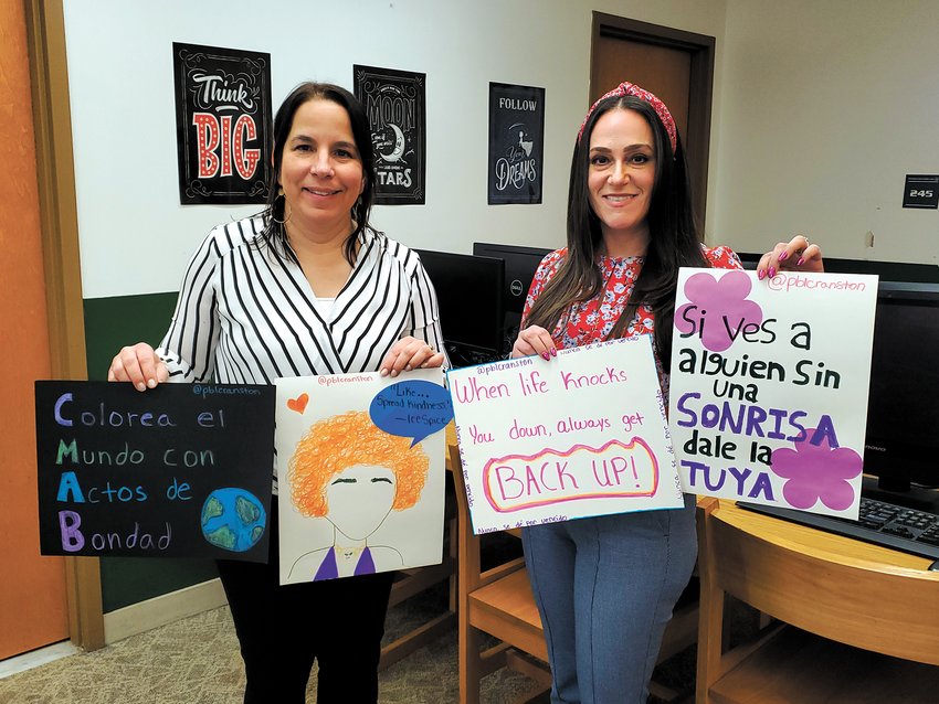 CREATING TIES WITH LANGUAGE: Cranston High School West World Language Department Chair Lauren King and Cranston High School East World Language Department Chair Amy Ricci-Tum show off posters created by their AP Spanish Language and Culture students in the Cranston High School East library on March 20. The pair have been working together with their AP Spanish students since fall on project-based learning that centers around kindness and positivity. (Photo by Stephanie Bernaba)