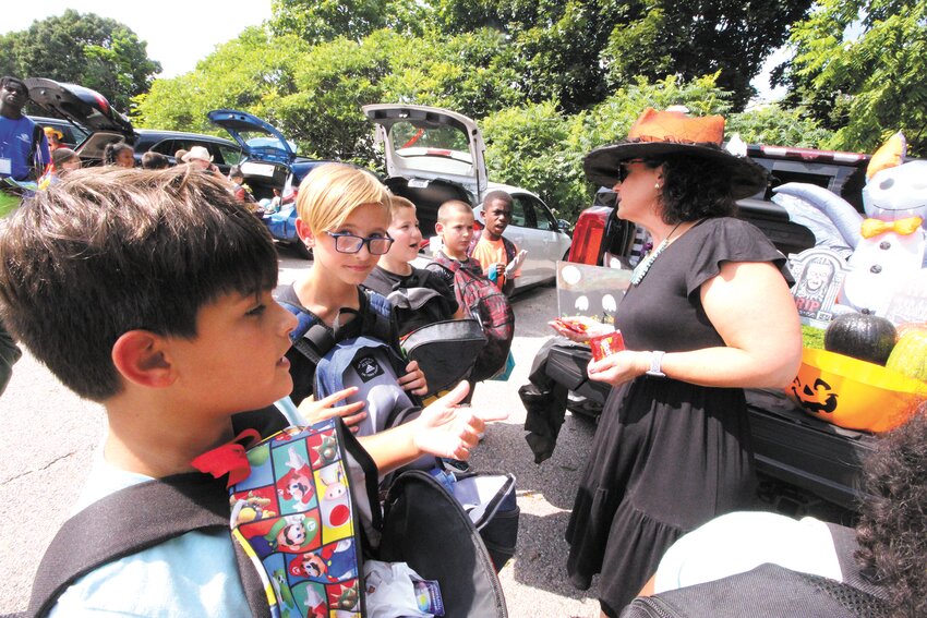 TIME TO BE SPOOKY: Dressed as a witch, Lara D&rsquo;Antuono, Chief Executive Officer of the Boys &amp; Girls Clubs of Warwick is surrounded by tick or treaters at the club&rsquo;s Halloween in August event. Story and more photos on page 8. (Warwick Beacon photos)