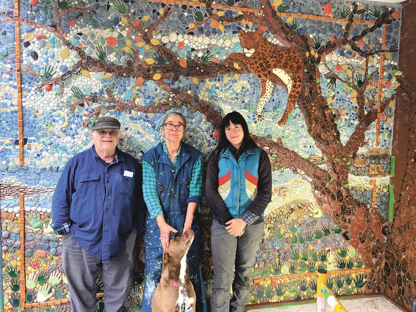 THE FINISHING TOUCHES: Peter Geisser, Mika Seeger and Jade Donaldson (from left to right) stand in front of the mural at Lippitt as it nears completion, along with Seeger&rsquo;s daughter&rsquo;s dog Bernie. Bernie, according to Seeger, has become a mascot for the project amongst the Lippitt students.
