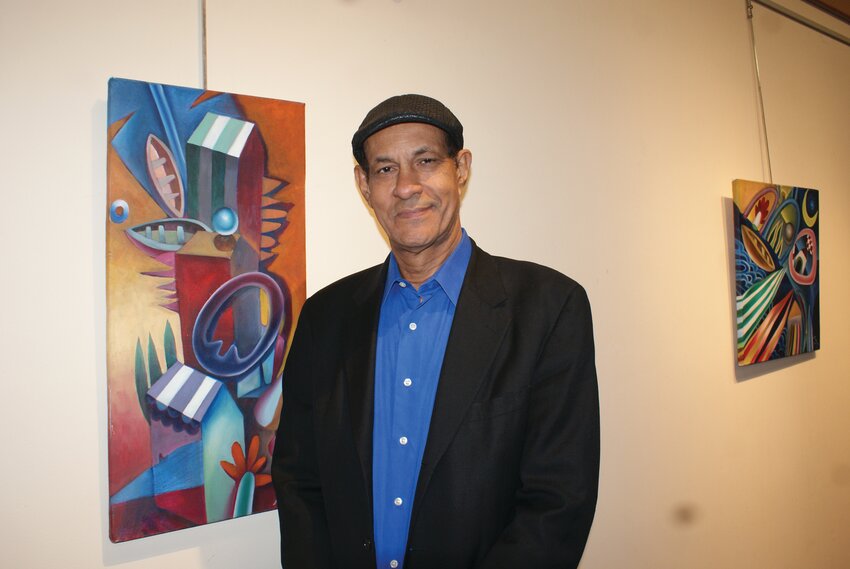 THE MAN HIMSELF: Arist Jose Sejo stands next to one of his paintings during the jose next to one of his paintings during the Grand Opening of his exhibition.