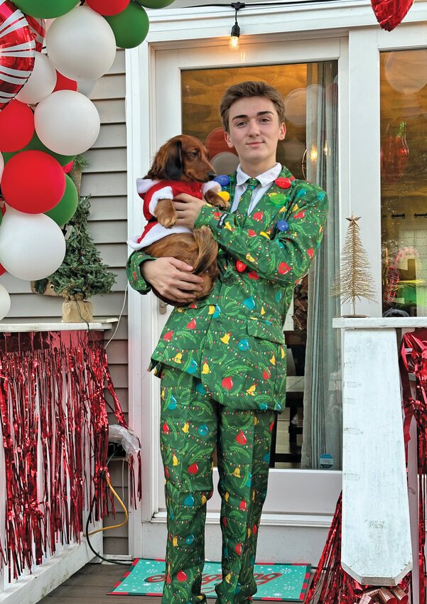 LIGHT THE TREE: Josh Clapprood wears his Christmas themed apparel and poses with the family dog, dressed as Santa, as he prepares for the seasonal twist on a Halloween party. (Submitted photo)