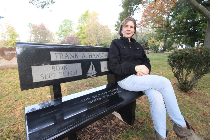 IN MEMORY OF FRANK HANSON JR.: Gloria Coppola who retired as a major crimes investigator from the  New York State Police (NYSP) Bureau of Criminal Investigation has hopes of finding remains of Frank Hanson who was last seen on July 12, 1947. She sits on a bench she bought and is across from the grave stone of Frank&rsquo;s parents at Pawtuxet Memorial Cemetery in Warwick. (Cranston Herald photos)