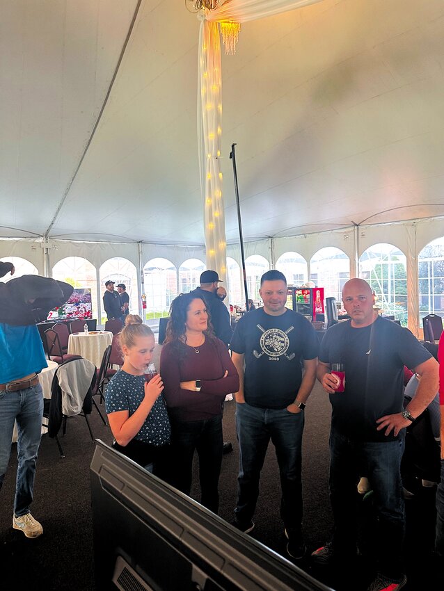 TAKING IN THE ACTION: Rocha&rsquo;s child Reilly and wife Jessica talk with firefighters Nick Ring and Nick Varras as they watch the tournament. (Submitted photo)