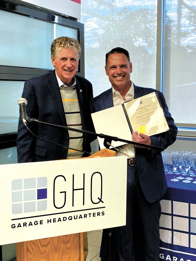 A MILESTONE MEMORY: Garage Headquarters President Scott Grace (at right)receives a proclamation from Governor Dan McKee at the Garage Headquarters&rsquo; celebration.