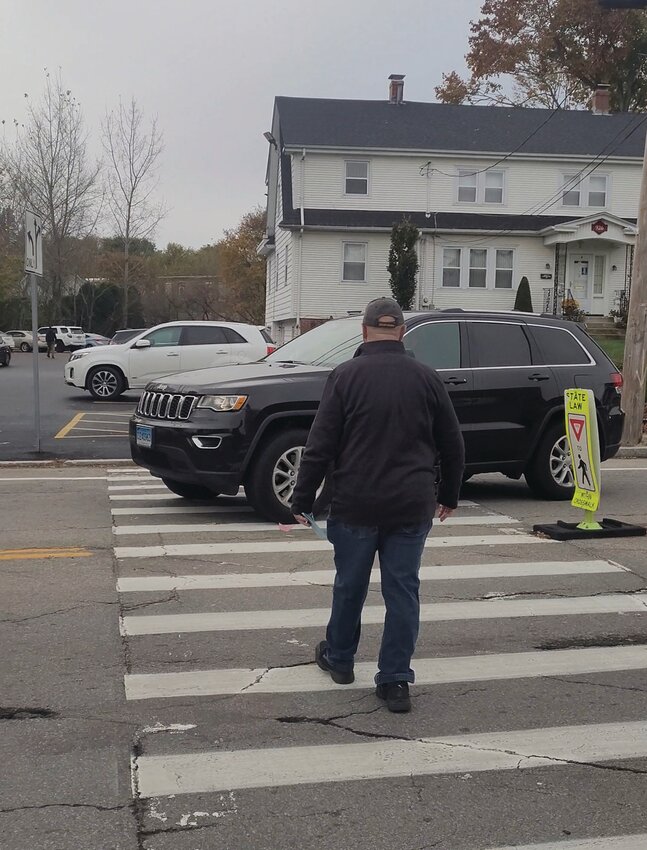 CLOSE CALL: Pedestrians attempt to cross Atwood Avenue outside St. Rocco Church following the school&rsquo;s Veterans Day prayer service on Friday. A driver narrowly missed several people in the crosswalk after failing to yield. Johnston Police cited the driver, based on video captured by the Johnston Sun Rise.