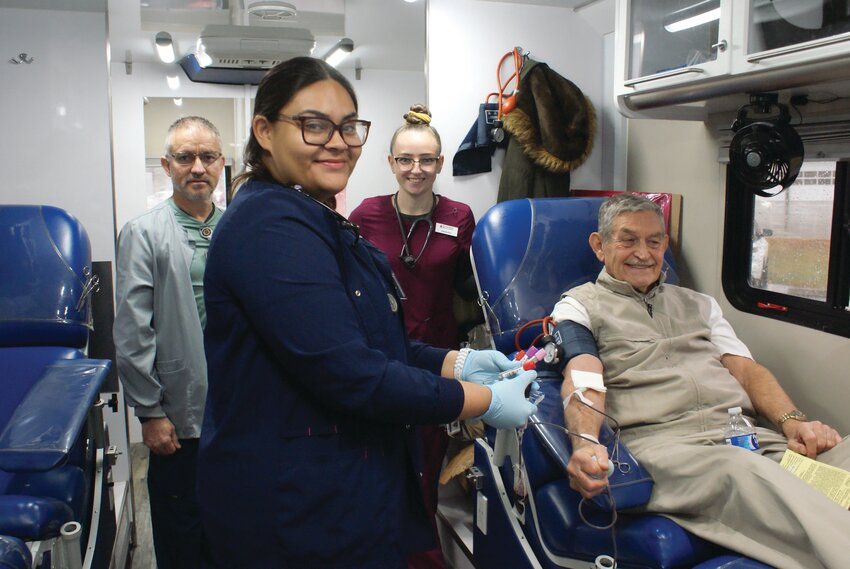 SEEING RED: Donor Parker Smith with phlebotomists Fredy Arias, and Gabriela Menjivar, and Samantha Falcone in the Bloodmobile. (Photo by Steve Popiel)