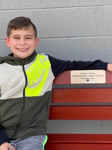 HOW IT ALL STARTED: Gunner DeCiccio, son of Adam, shows off his Dad&rsquo;s bench at Cranston West field.