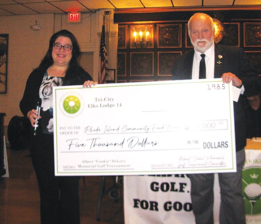 MIGHT MATCH: Kelly Seigh, Director of Corporate/Community Relations for the RI Food Bank, holds a mock check with Golf Tourney Co-Chairman Bob Hartington for $5,000 that will mushroom into $10,000 by way of a matching grant. (Photos by Bruce Caldwell)