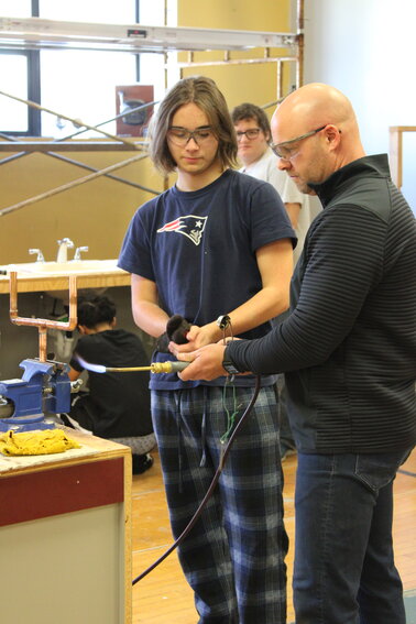 TOOLS OF THE TRADE: Christopher Richard, the plumbing and pipefitting teacher in the CTE program at Cranston High School East works with 11th grader Stanton Morretti at the trade. (Photo provided by Cranston Public Schools)