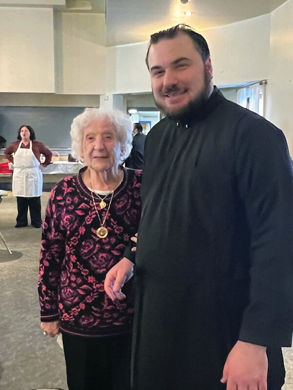 DELIGHTFUL DUTY: Church of the Annunciation Assistant Pastor Father Nick Lanzourakis joins 100-yuear-old Helen DeMaio after presenting her with a special piece of the Vasilopita Bread in honor of being the parish&rsquo;s centenarian.