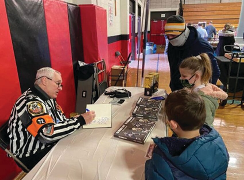 HALL OF FAMER: USA Hockey Hall of Famer Paul Stewart autographing items for young fans at the last CSCS show last February. (Submitted photo)