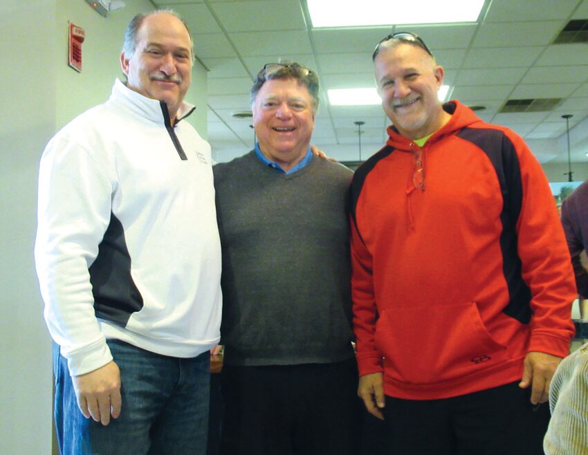 CHAIR&rsquo;S CORNER: Johnston Town Councilman Robert Civettti (left) and his brother David (right) get a warm welcome from Steve Placella, who has long served as chairman of the Ricky Salzillo Memorial Game Dinner. (Sun Rise photos by Pete Fontaine)
