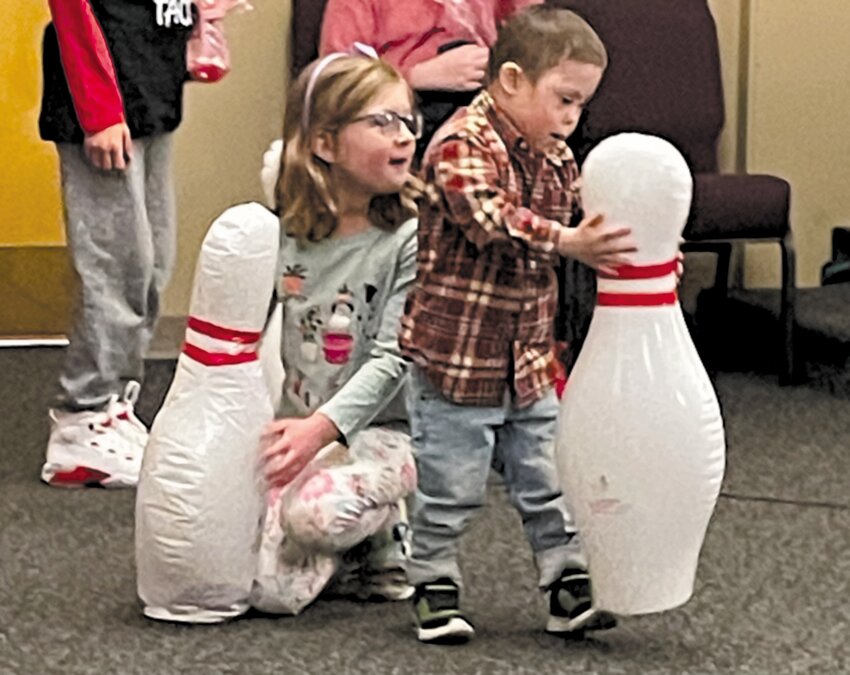 FRIENDS FOREVER: Lumen Desrochers age 6, helps her friend, Luca play with the bowling pin. Luca has been a patient of Magnolia Pediatrics since he was two months old.