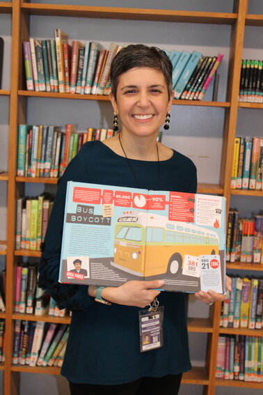 THE GRANTEE: Park View Middle School library media  specialist Stephanie Mills shows one of the popular biographies  that needed a refresh and was included in the set  of new books ordered with the LORI mini-grant. (Photo  courtesy of Cranston Public Schools)